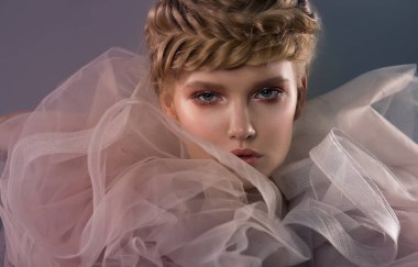 Queen, yakın plan yaratıcı portre. Hava tülünden büyük ve görkemli bir tasması olan bir kadının fantezi portresi. Saç örgülerinden bir taç. Renk ışığı. Fantastik görüntü.