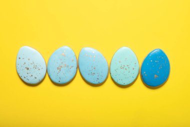 Sarı arka planda Paskalya kurabiyeleri. Mesaj için yer. Yukarıdan görüntüle.