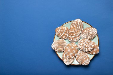 Mavi arka planda bir tabakta paskalya kurabiyesi. Üst Manzara. Metin için yer.