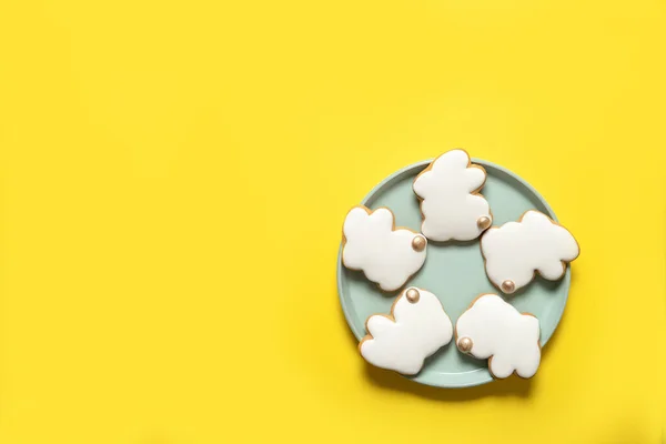 Easter cookies on a plate on a yellow background. Top view. Place for text.