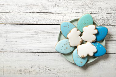 Ahşap arka planda bir tabakta paskalya kurabiyesi. Paskalya yumurtaları. Paskalya tavşanları. Metin için yer.