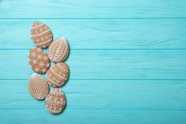 Mavi arka planda bir tabakta paskalya kurabiyesi. Paskalya yumurtaları. Paskalya tavşanları. Mesaj için yer. Üst Manzara. Bir bardak süt.