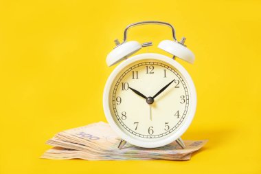 Sarı arka planda beyaz çalar saat ve para. Ukrayna Hryvnia 'sı. Mali işler. Politika.