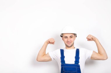Beyaz arka planda kask takan neşeli, güçlü bir adam. Metin için yer