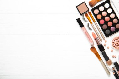 Dekoratif kozmetik ürünleri ve makyaj fırçaları beyaz arka planda, üst tarafta. Metin için yer