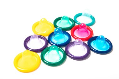 Beyaz arka planda izole edilmiş renkli prezervatifler. Doğum kontrol..