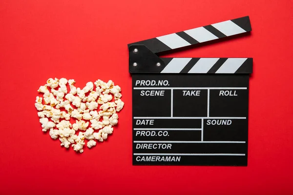 映画のクラッパーとポップコーン上の赤い背景 — ストック写真