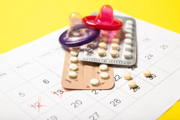 Kadın Doğum Kontrol Hapları Renkli Prezervatifler Bir Takvim Yakın Plan — Stok fotoğraf