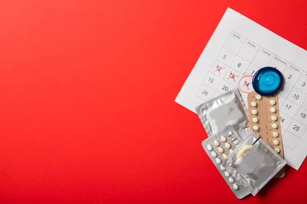 Kırmızı Arka Planda Doğum Kontrol Hapları Prezervatifler Takvim Metin Için — Stok fotoğraf