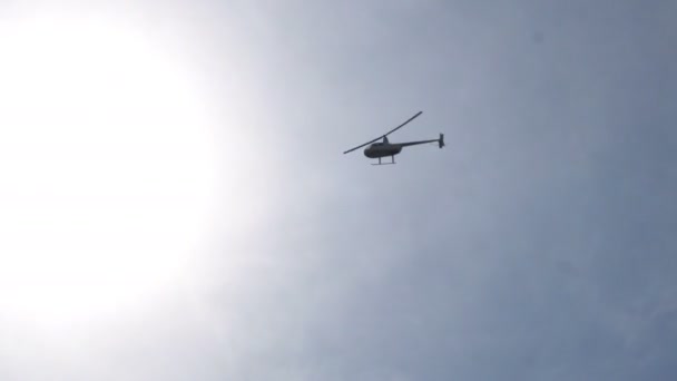 Helikopter som flyr over jorden på bakgrunn av klar himmel – stockvideo