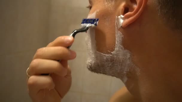 Dospělý muž holení s pěnou a manuální razer — Stock video