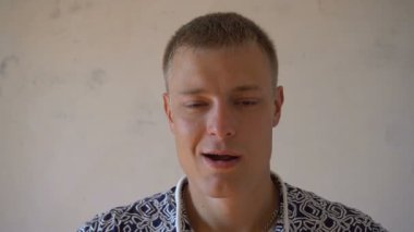 Gülümsemek gülümseyen genç adamın beyaz arka plan üzerinde izole kamera bakıyor. Yüz ifadeleri değiştirir sakallı bir adam portresi. Kameraya bakarak t-shirt ile gurur ve memnun adam