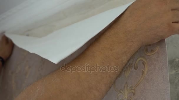 Proces klejenia tapeta na ścianie, z ręki pracownika jest płynne Tapety — Wideo stockowe