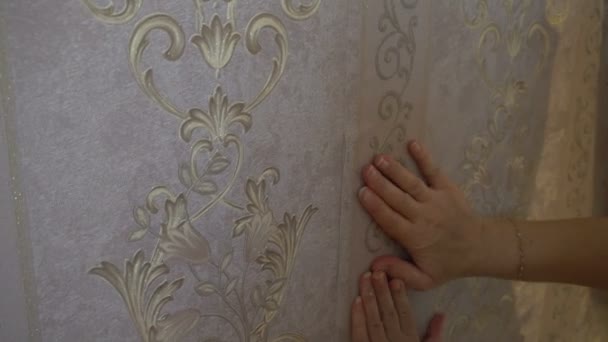 Процес склеювання шпалер на стіні,рука працівника гладкі шпалери — стокове відео