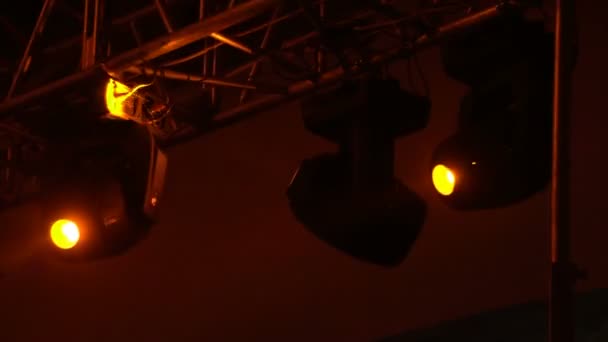 Strobe lights emitting different color beams hanging under the ceiling — Stock Video