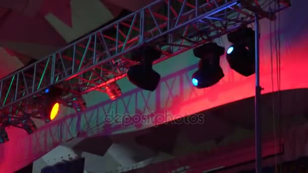 Strobe lights emitting different color beams hanging under the ceiling — Stock Video