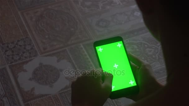 Un joven y un teléfono inteligente de pantalla verde — Vídeos de Stock