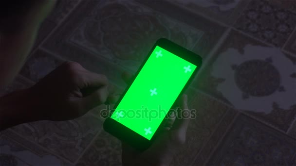 Un joven y un teléfono inteligente de pantalla verde — Vídeos de Stock