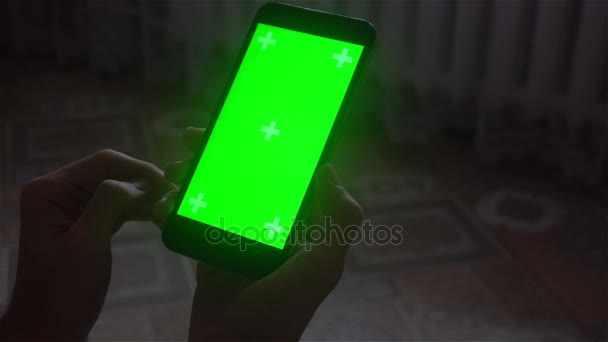 Een jonge man en een groen scherm smartphone — Stockvideo