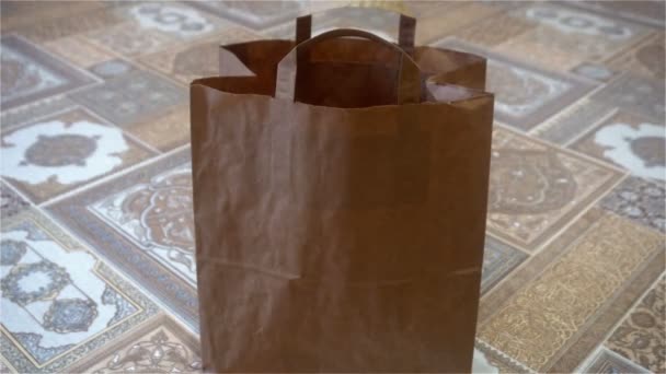 Uma mão feminina pega um saco de papel, de pé na moldura — Vídeo de Stock
