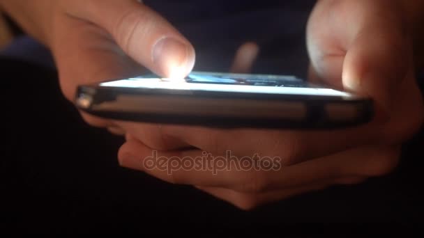 Closeup of hands of a young man flipping through the news on the smartphone — Stock Video