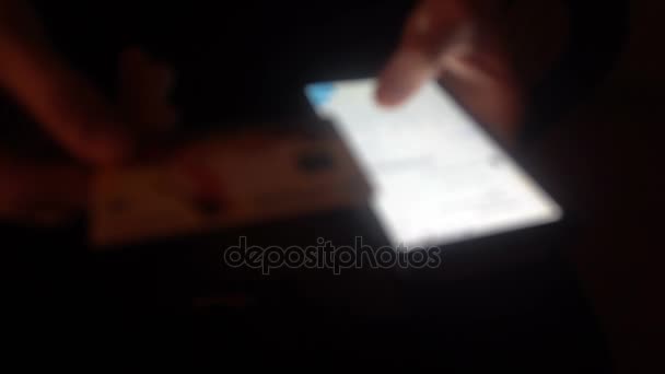 Close-up van handen van een jonge man flipping door middel van het nieuws op de smartphone, schieten onscherp — Stockvideo