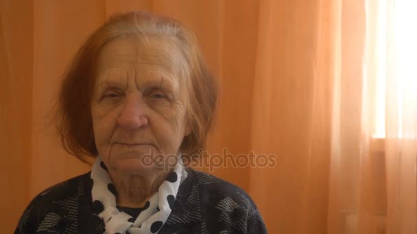 Porträt einer älteren Frau, die in die Kamera blickt — Stockvideo