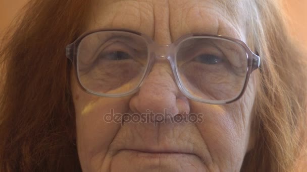 Portréja egy idős asszony nézi a kamera közelről — Stock videók