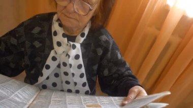 Gözlüklü yaşlı kadın gazete dikkatle okur