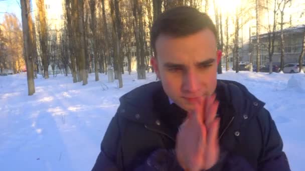 若い男が暖かく、冬、雪の中に立って維持しよう — ストック動画