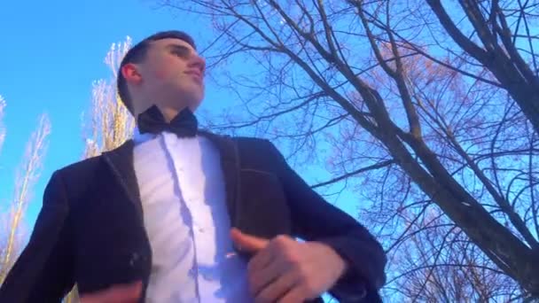 Young man posing in a tuxedo in the winter against the white snow,shot in retro style — Stock Video