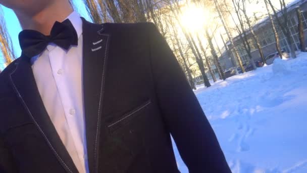 Young man posing in a tuxedo in the winter against the white snow,shot in retro style — Stock Video