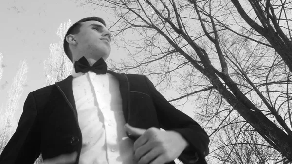 genç adam beyaz kar karşı kışın bir smokin içinde poz çekim retro tarzında