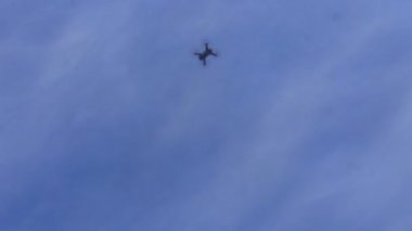 Aşağıdan çekim mavi gökyüzüne doğru quadcopter soars