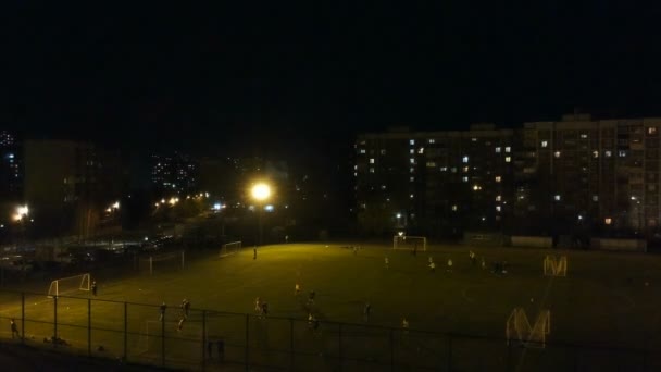 Стрельба с квадрокоптером, обзор на городском футбольном поле ночью — стоковое видео