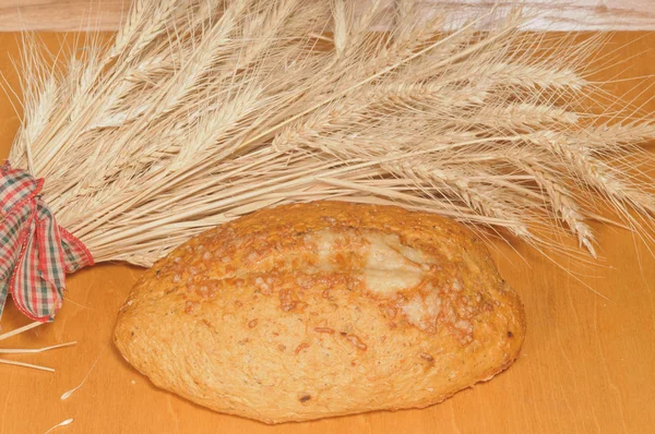 Loaf of Sliced French Bread with wheat sheaves on a cutting board