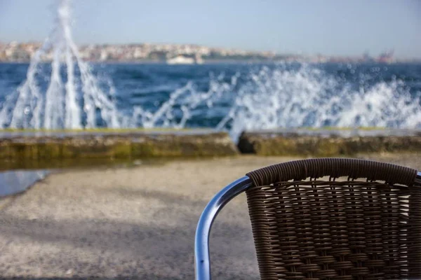 Arka planda dalgalar ile denizin yakınında sandalye — Stok fotoğraf