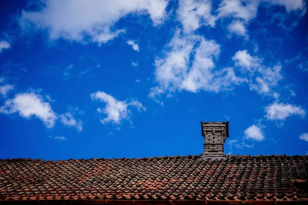 Rooftop with chimney  on the background with the blue sky