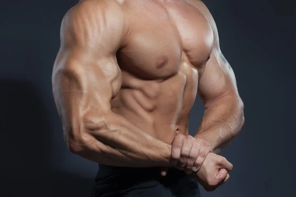 Portret silny zdrowy przystojny Model Fitness lekkoatletycznego mężczyzna pozowanie blisko ciemny szary ściany — Zdjęcie stockowe