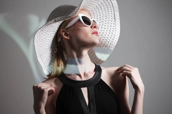 Joven hermosa mujer de moda con maquillaje de moda. Modelo mirando a la cámara, con gafas con estilo, sombrero. Moda femenina, concepto de belleza . — Foto de Stock