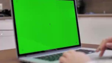 Laptop yeşil ekranlı dizüstü bilgisayar kullanan bir kadın, 4k 'lık çekim. Teknoloji, kroma anahtarı, şablon, model ve eğlence konsepti..