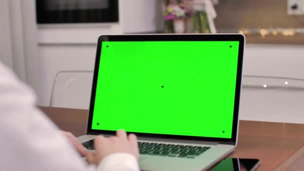 Žena používající notebook se zelenou obrazovkou, 4k záběr. Technologie, chroma klíč, šablona, mockup a koncepce zábavy.