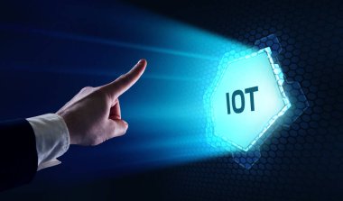 Nesnelerin interneti - IOT konsepti. İşadamı IOT ürünleri ve çözümler sunuyor. Genç işadamı sanal ekranda IoT metin ile soyut çipi seçin