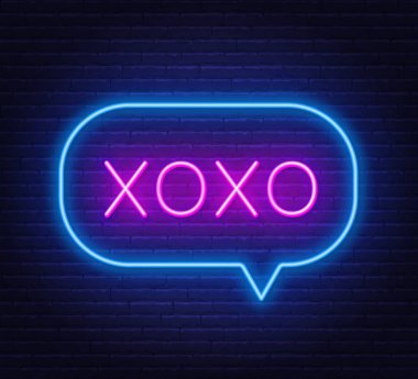 Neon sign xoxo on a dark background.