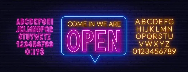 Girin, tuğla duvarda açık neon tabela var..