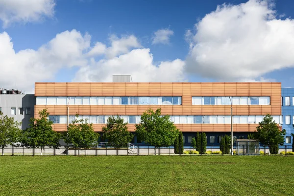 Modern factory building in green field with blue sky