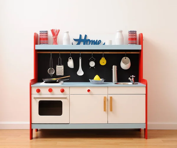 Designer toy kitchen in white, red and blue with drawers, oven, stove and sink equipped with kitchen utensils