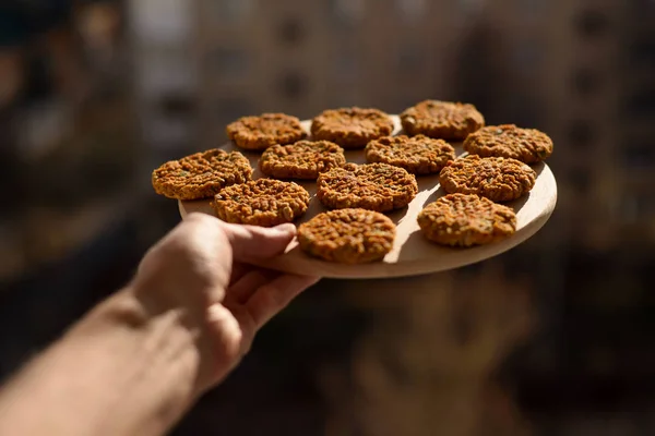 Vegan gluten free breakfast cookies. Man hand with homemade oatm