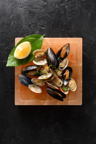 Salt block cooking. Vongole seafood mussels and clams in shells