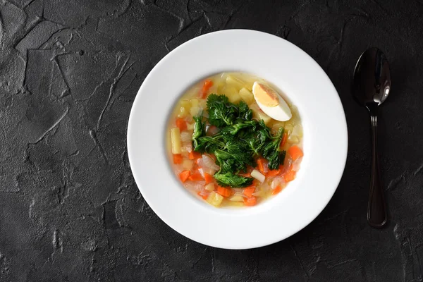Cooking with wild herbs. Homemade vegetable soup with nettle and egg in white plate on black background top view copy space — Stock Image Cooking Wild Herbs Homemade Vegetable Soup Nettle Egg White Plate Royalty Free Stock Images